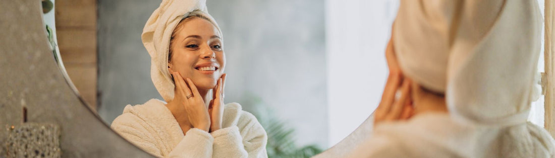 femme se touchant le visage devant un miroir dans une salle de bain