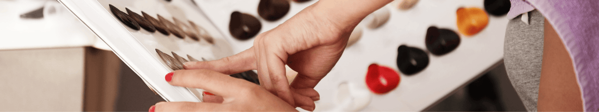 femme qui choisis sa coloration sur un nuancier